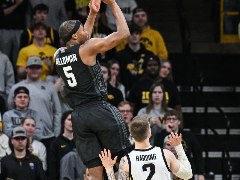 Mar 6, 2025; Iowa City, Iowa, USA; Michigan State Spartans guard Tre Holloman (5) shoots the ball over Iowa Hawkeyes guard Brock Harding (2) during the second half at Carver-Hawkeye Arena. Mandatory Credit: Jeffrey Becker-Imagn Images