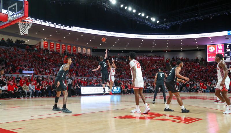 Jan 28, 2023; Houston, Texas, USA; Houston Cougars guard Emanuel Sharp (21) makes a three point basket against Cincinnati Bearcats forward Viktor Lakhin (30) in the first half at Fertitta Center. Mandatory Credit: Thomas Shea-USA TODAY Sports