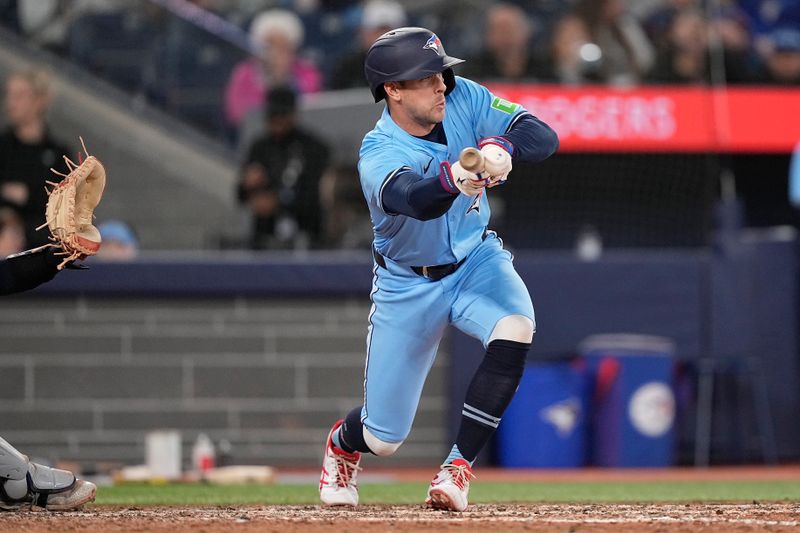 May 4, 2025; Toronto, Ontario, CAN; Toronto Blue Jays third baseman Ernie Clement (22) advances two runners with a sacrifice bunt against the Cleveland Guardians during the eighth inning at Rogers Centre. Mandatory Credit: John E. Sokolowski-Imagn Images