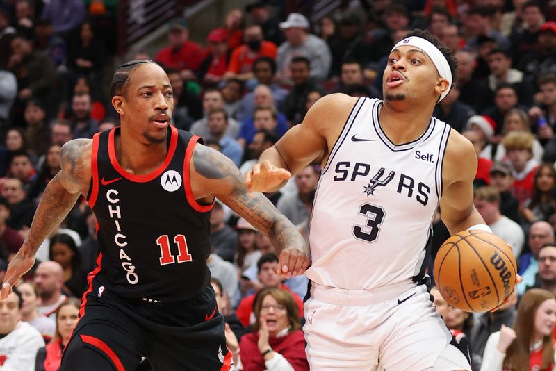 CHICAGO, ILLINOIS - DECEMBER 21: Keldon Johnson #3 of the San Antonio Spurs drives to the basket against DeMar DeRozan #11 of the Chicago Bulls during the first half at the United Center on December 21, 2023 in Chicago, Illinois. NOTE TO USER: User expressly acknowledges and agrees that, by downloading and or using this photograph, User is consenting to the terms and conditions of the Getty Images License Agreement.  (Photo by Michael Reaves/Getty Images)