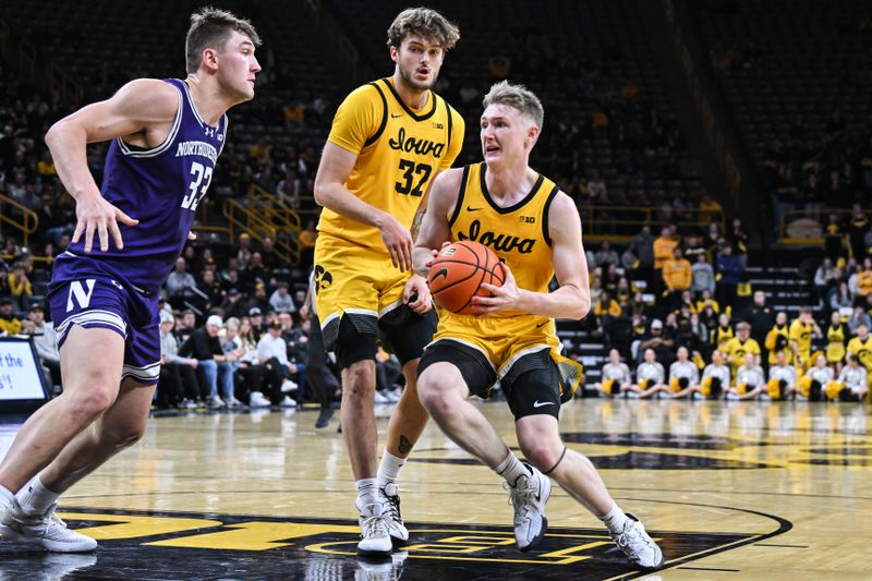 Dec 3, 2024; Iowa City, Iowa, USA; Iowa Hawkeyes guard Josh Dix (4) goes to the basket as forward Owen Freeman (32) looks on and Northwestern Wildcats forward Luke Hunger (33) defends during the second half at Carver-Hawkeye Arena. Mandatory Credit: Jeffrey Becker-Imagn Images