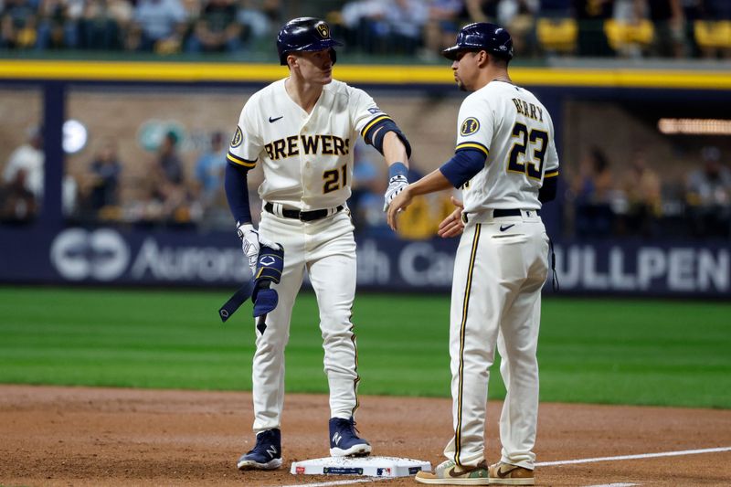 Oct 4, 2023; Milwaukee, Wisconsin, USA; Milwaukee Brewers bullpen catcher Daniel de Mondesert (21) reacts at first with first base coach Quintin Berry (23)  after hitting a single in the first inning against the Arizona Diamondbacks during game two of the Wildcard series for the 2023 MLB playoffs at American Family Field. Mandatory Credit: Kamil Krzaczynski-USA TODAY Sports