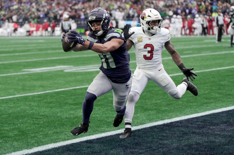 Seattle Seahawks wide receiver Jaxon Smith-Njigba (11) scores a touchdown as Arizona Cardinals safety Budda Baker (3) defends during the first half of an NFL football game Sunday, Nov. 24, 2024, in Seattle. (AP Photo/Stephen Brashear)