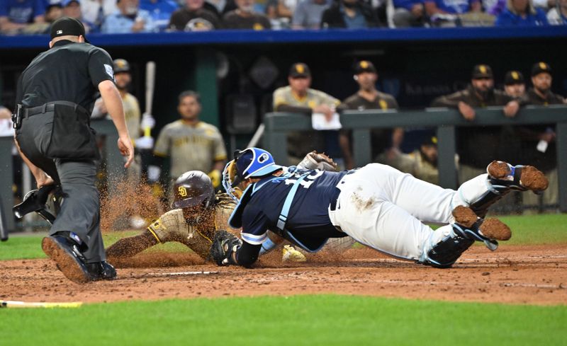 May 31, 2024; Kansas City, Missouri, USA;  San Diego Padres right fielder Fernando Tatis Jr. (23) is tagged out at home plate by Kansas City Royals catcher Salvador Perez (13) in the sixth inning at Kauffman Stadium. Mandatory Credit: Peter Aiken-USA TODAY Sports