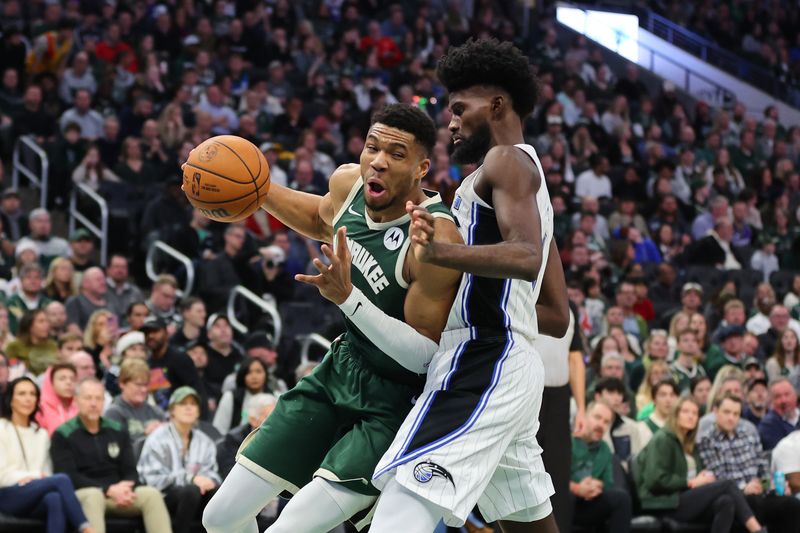 MILWAUKEE, WISCONSIN - DECEMBER 21: Giannis Antetokounmpo #34 of the Milwaukee Bucks is defended by Jonathan Isaac #1 of the Orlando Magic during a game at Fiserv Forum on December 21, 2023 in Milwaukee, Wisconsin. NOTE TO USER: User expressly acknowledges and agrees that, by downloading and or using this photograph, User is consenting to the terms and conditions of the Getty Images License Agreement. (Photo by Stacy Revere/Getty Images)