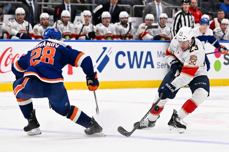 Jan 27, 2024; Elmont, New York, USA; New York Islanders defenseman Alexander Romanov (28) defends against Florida Panthers center Carter Verhaeghe (23) during the third period at UBS Arena. Mandatory Credit: Dennis Schneidler-USA TODAY Sports