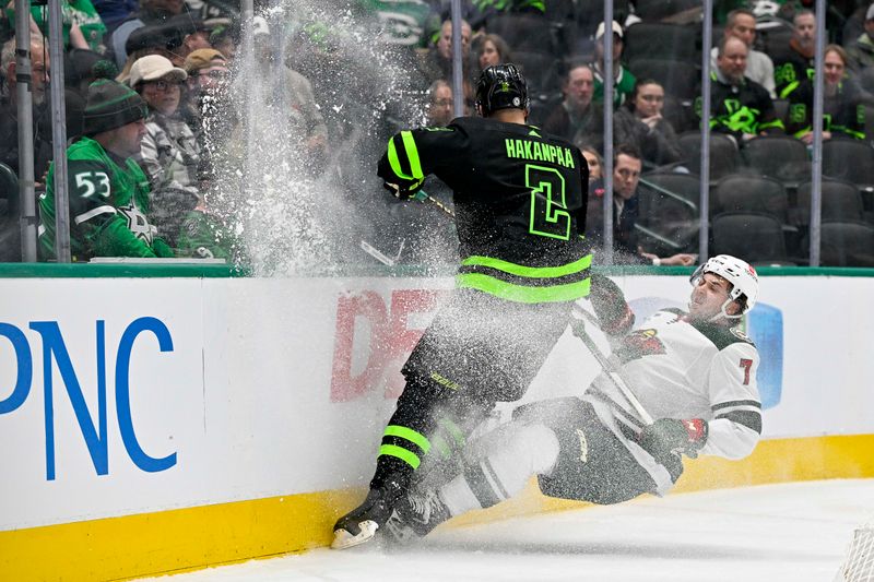 Jan 10, 2024; Dallas, Texas, USA; Dallas Stars defenseman Jani Hakanpaa (2) and Minnesota Wild defenseman Brock Faber (7) chase the puck into the boards during the first period at the American Airlines Center. Mandatory Credit: Jerome Miron-USA TODAY Sports