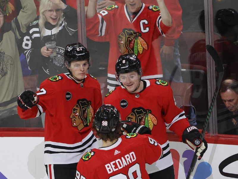 Dec 22, 2023; Chicago, Illinois, USA; Chicago Blackhawks center Ryan Donato (8) celebrates with left wing Lukas Reichel (27) and center Connor Bedard (98) after scoring against the Montreal Canadiens during the first period at United Center. Mandatory Credit: Kamil Krzaczynski-USA TODAY Sports