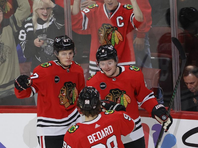 Dec 22, 2023; Chicago, Illinois, USA; Chicago Blackhawks center Ryan Donato (8) celebrates with left wing Lukas Reichel (27) and center Connor Bedard (98) after scoring against the Montreal Canadiens during the first period at United Center. Mandatory Credit: Kamil Krzaczynski-USA TODAY Sports