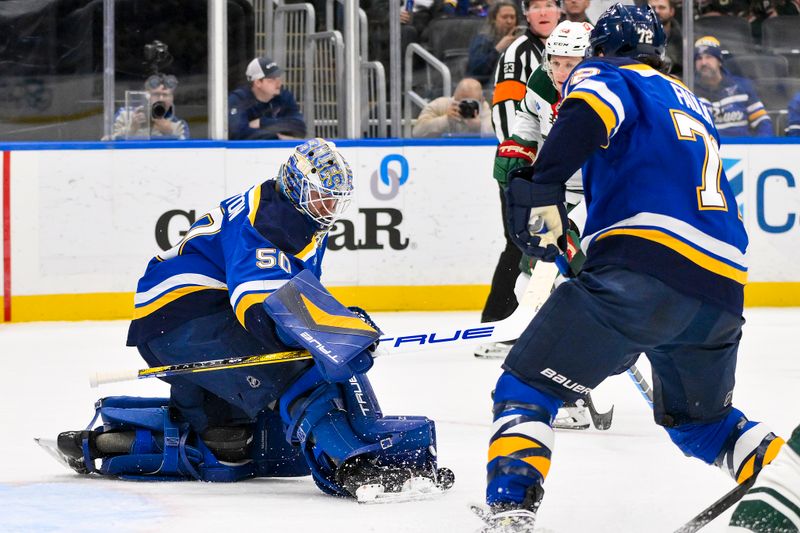 Nov 19, 2024; St. Louis, Missouri, USA;  St. Louis Blues goaltender Jordan Binnington (50) defends the net against the Minnesota Wild during the first period at Enterprise Center. Mandatory Credit: Jeff Curry-Imagn Images