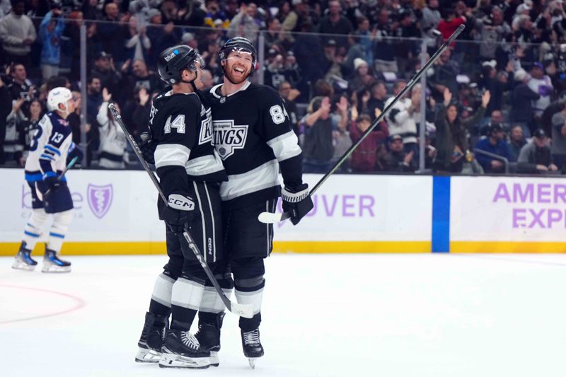 Nov 27, 2024; Los Angeles, California, USA; LA Kings defenseman Mikey Anderson (44) and defenseman Vladislav Gavrikov (84) celebrate after a goal against the Winnipeg Jets in the third period at Crypto.com Arena. Mandatory Credit: Kirby Lee-Imagn Images