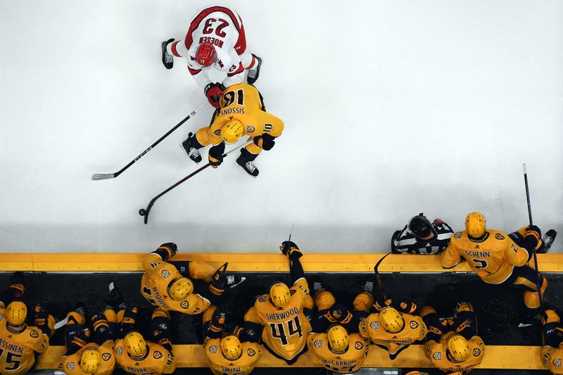 Dec 27, 2023; Nashville, Tennessee, USA; Nashville Predators center Colton Sissons (10) and Carolina Hurricanes right wing Stefan Noesen (23) battle for a puck during the third period at Bridgestone Arena. Mandatory Credit: Christopher Hanewinckel-USA TODAY Sports