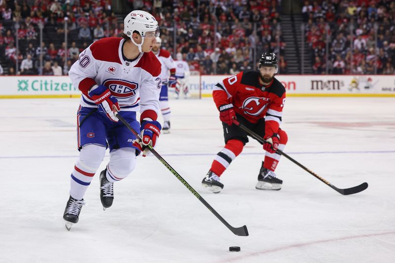 Nov 7, 2024; Newark, New Jersey, USA; Montreal Canadiens left wing Juraj Slafkovsky (20) skates with the puck against New Jersey Devils left wing Tomas Tatar (90) during the first period at Prudential Center. Mandatory Credit: Ed Mulholland-Imagn Images