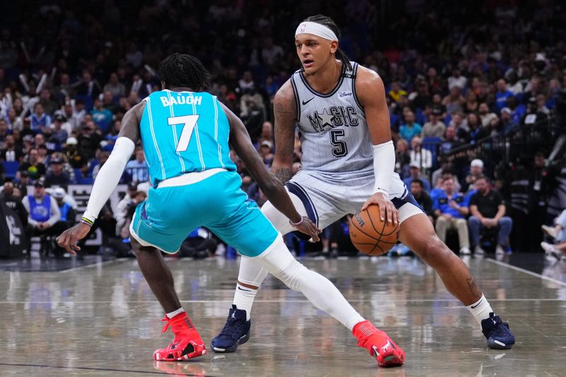 ORLANDO, FLORIDA - FEBRUARY 12: Paolo Banchero #5 of the Orlando Magic dribbles the ball against Damion Baugh #7 of the Charlotte Hornets during the fourth quarter at Kia Center on February 12, 2025 in Orlando, Florida. NOTE TO USER: User expressly acknowledges and agrees that, by downloading and or using this photograph, user is consenting to the terms and conditions of the Getty Images License Agreement. (Photo by Rich Storry/Getty Images)