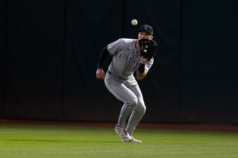 May 22, 2024; Oakland, California, USA; Colorado Rockies center fielder Brenton Doyle (9) makes a catch of a line drive off the bat of Oakland Athletics right fielder Tyler Nevin  (not pictured) during the seventh inning at Oakland-Alameda County Coliseum. Mandatory Credit: D. Ross Cameron-USA TODAY Sports