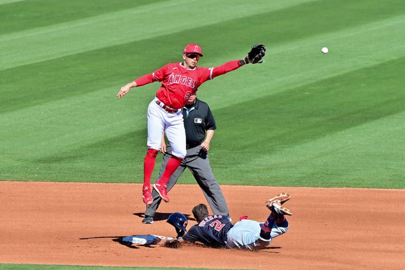 Feb 29, 2024; Tempe, Arizona, USA;  Los Angeles Angels shortstop Zach Neto (9) misses the catch as Cleveland Guardians third baseman Tyler Freeman (2) steals a base in the third inning during a spring training game at Tempe Diablo Stadium. Mandatory Credit: Matt Kartozian-USA TODAY Sports