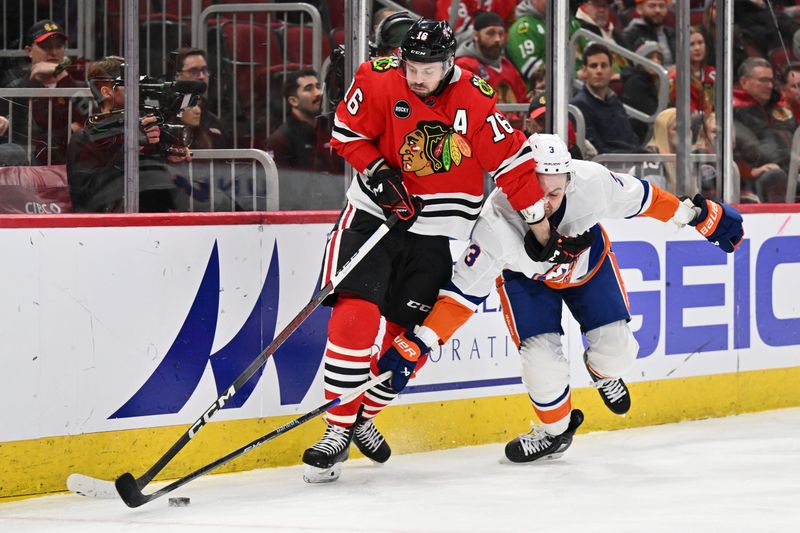 Jan 19, 2024; Chicago, Illinois, USA; Chicago Blackhawks forward Jason Dickinson (16) and New York Islanders defenseman Adam Pelech (3) battle for control of the puck in the third period at United Center. Mandatory Credit: Jamie Sabau-USA TODAY Sports