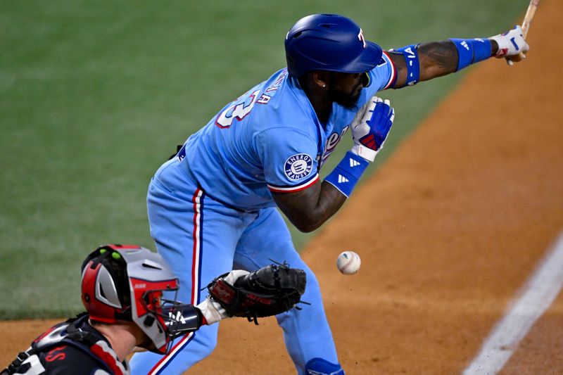 Aug 18, 2024; Arlington, Texas, USA; Texas Rangers right fielder Adolis Garcia (53) misses and is hit by a foul tip during the first inning against the Minnesota Twins at Globe Life Field. Mandatory Credit: Jerome Miron-USA TODAY Sports