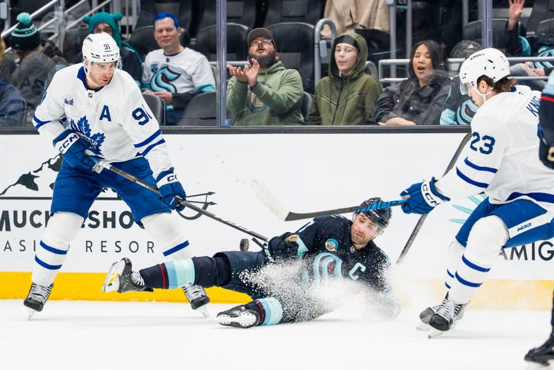 Jan 29, 2026; Seattle, Washington, USA; Seattle Kraken forward Jordan Eberle (7) battles Toronto Maple Leafs forward John Tavares (91) and forward Matthew Knies (23) for the puck during the third period at Climate Pledge Arena. Mandatory Credit: Stephen Brashear-Imagn Images