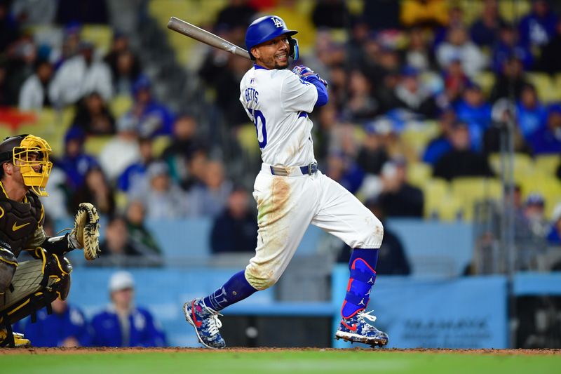 Apr 13, 2024; Los Angeles, California, USA; Los Angeles Dodgers shortstop Mookie Betts (50) hits an RBI single against the San Diego Padres during the sixth inning at Dodger Stadium. Mandatory Credit: Gary A. Vasquez-USA TODAY Sports