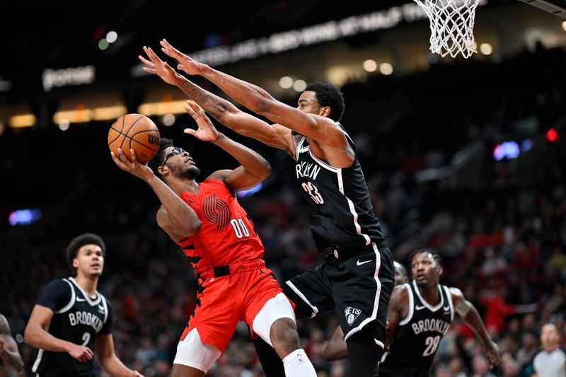 PORTLAND, OREGON - JANUARY 17: Scoot Henderson #00 of the Portland Trail Blazers is well guarded by Nic Claxton #33 of the Brooklyn Nets during the third quarter at the Moda Center on January 17, 2024 in Portland, Oregon. The Portland Trail Blazers won 105-103. NOTE TO USER: User expressly acknowledges and agrees that, by downloading and or using this photograph, User is consenting to the terms and conditions of the Getty Images License Agreement. (Photo by Alika Jenner/Getty Images)