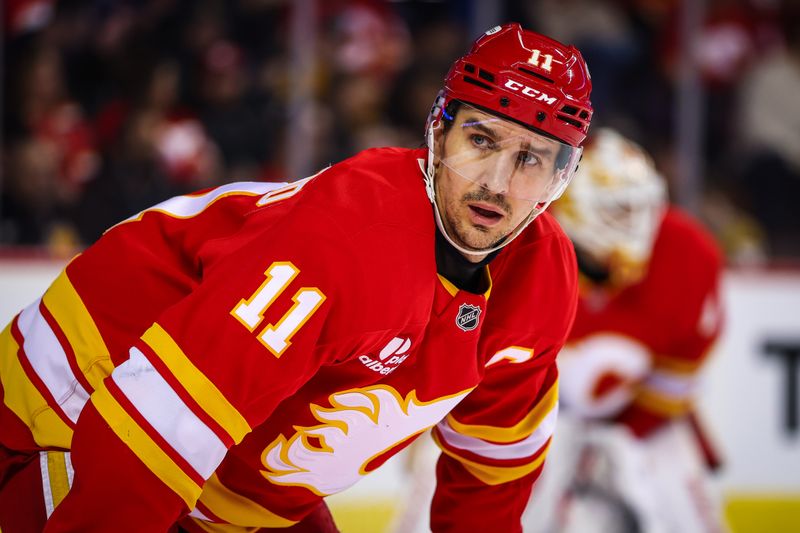 Dec 20, 2025; Calgary, Alberta, CAN; Calgary Flames center Mikael Backlund (11) during the face off against the Vegas Golden Knights during the first period at Scotiabank Saddledome. Mandatory Credit: Sergei Belski-Imagn Images