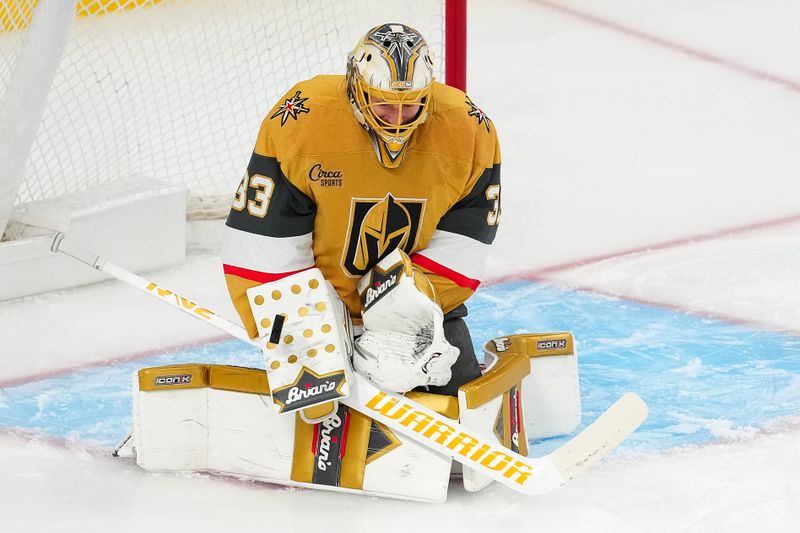 Apr 20, 2025; Las Vegas, Nevada, USA; Vegas Golden Knights goaltender Adin Hill (33) makes a save against the Minnesota Wild during the third period of game one of the first round of the 2025 Stanley Cup Playoffs at T-Mobile Arena. Mandatory Credit: Stephen R. Sylvanie-Imagn Images