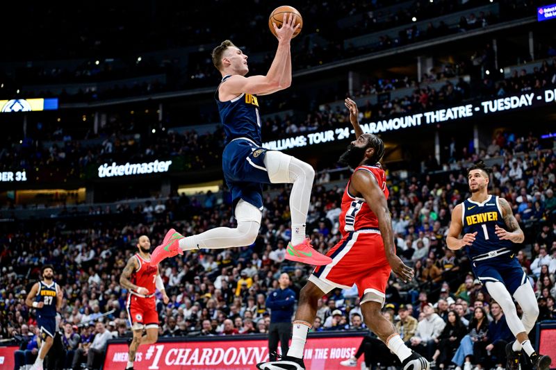 DENVER, COLORADO - DECEMBER 13: Christian Braun #0 of the Denver Nuggets scores on a layup under coverage by James Harden #1 of the LA Clippers in the first half at Ball Arena on December 13, 2024, 2024 in Denver, Colorado. NOTE TO USER: User expressly acknowledges and agrees that, by downloading and or using this photograph, User is consenting to the terms and conditions of the Getty Images License Agreement. (Photo by Dustin Bradford/Getty Images)