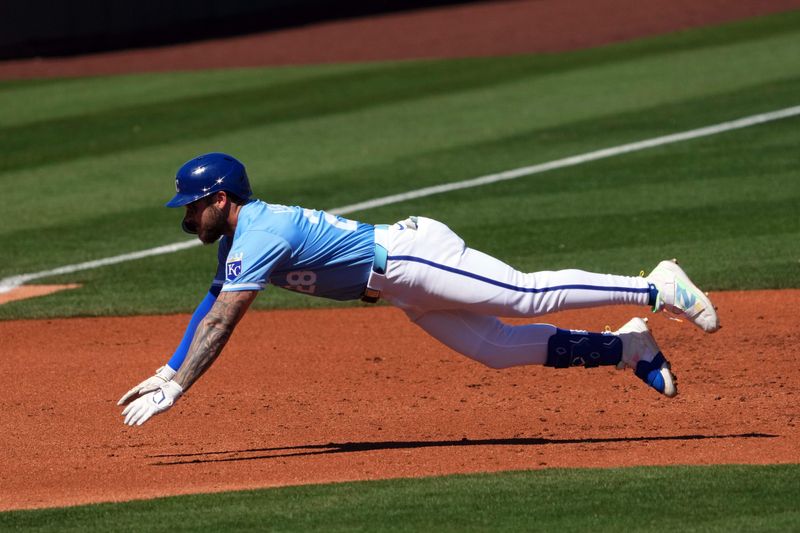 Mar 11, 2024; Surprise, Arizona, USA; Kansas City Royals center fielder Kyle Isbel (28) dives into third base for a triple against the San Francisco Giants during the second inning at Surprise Stadium. Mandatory Credit: Joe Camporeale-USA TODAY Sports