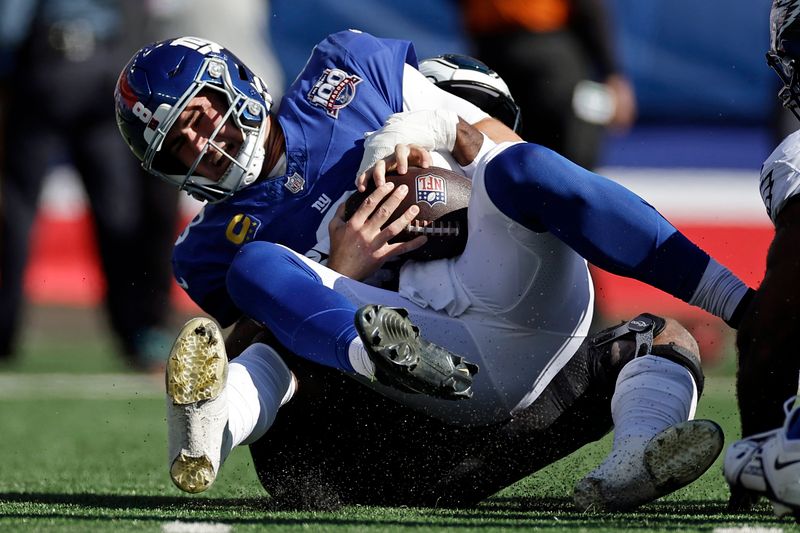 New York Giants quarterback Daniel Jones (8) is sacked by Philadelphia Eagles linebacker Josh Sweat (19) during an NFL football game Sunday, Oct. 20, 2024, in East Rutherford, N.J. (AP Photo/Adam Hunger)