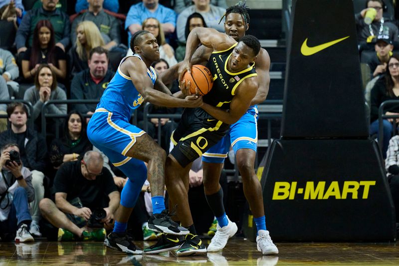 Feb 11, 2023; Eugene, Oregon, USA; UCLA Bruins guard David Singleton (34) ties up Oregon Ducks center N'Faly Dante (1) during the second half with help from UCLA Bruins forward Kenneth Nwuba (14) at Matthew Knight Arena. Mandatory Credit: Troy Wayrynen-USA TODAY Sports