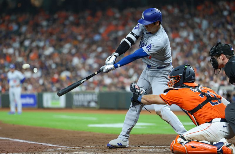 Jul 26, 2024; Houston, Texas, USA; Los Angeles Dodgers designated hitter Shohei Ohtani (17) hits a fly ball during the second inning against the Houston Astros at Minute Maid Park. Mandatory Credit: Troy Taormina-USA TODAY Sports