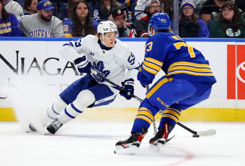 Mar 14, 2026; Buffalo, New York, USA;  Toronto Maple Leafs right wing Easton Cowan (53) skates with the puck as Buffalo Sabres center Ryan McLeod (71) defends the puck during the third period at KeyBank Center. Mandatory Credit: Timothy T. Ludwig-Imagn Images
