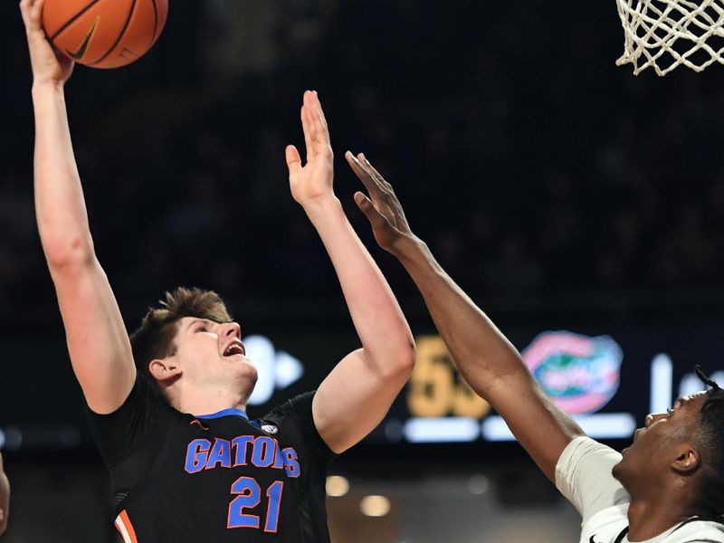 Mar 9, 2024; Nashville, Tennessee, USA; Florida Gators forward Alex Condon (21) scores against Vanderbilt Commodores forward JaQualon Roberts (24) during the second half at Memorial Gymnasium. Mandatory Credit: Christopher Hanewinckel-USA TODAY Sports