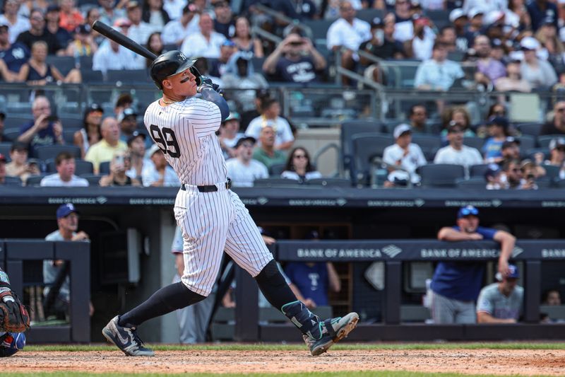 Aug 11, 2024; Bronx, New York, USA; New York Yankees center fielder Aaron Judge (99) hits a solo home run during the seventh inning against the Texas Rangers at Yankee Stadium. Mandatory Credit: Vincent Carchietta-USA TODAY Sports