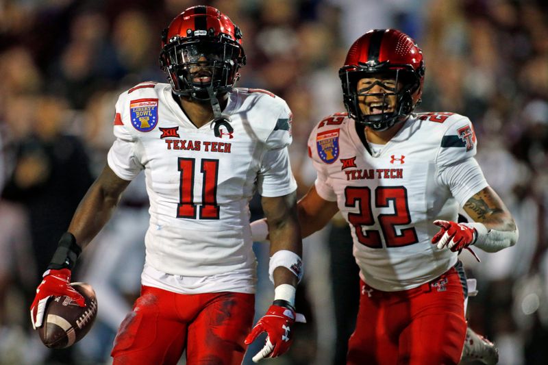 Dec 28, 2021; Memphis, TN, USA; Texas Tech Red Raiders defensive back Eric Monroe (11) and defensive back Reggie Pearson Jr. (22) react after an interception during the second half against the Mississippi State Bulldogs at Liberty Bowl Stadium. Mandatory Credit: Petre Thomas-USA TODAY Sports