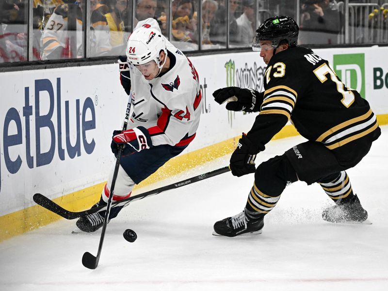 Feb 10, 2024; Boston, Massachusetts, USA; Washington Capitals center Connor McMichael (24) controls the puck against Boston Bruins defenseman Charlie McAvoy (73) during the second period at the TD Garden. Mandatory Credit: Brian Fluharty-USA TODAY Sports