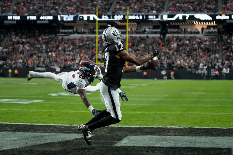 Las Vegas Raiders wide receiver Davante Adams (17) makes a touchdown catch in front of Denver Broncos cornerback Ja'Quan McMillian (29) during the first half of an NFL football game, Sunday, Jan. 7, 2024 in Las Vegas. (AP Photo/John Locher)