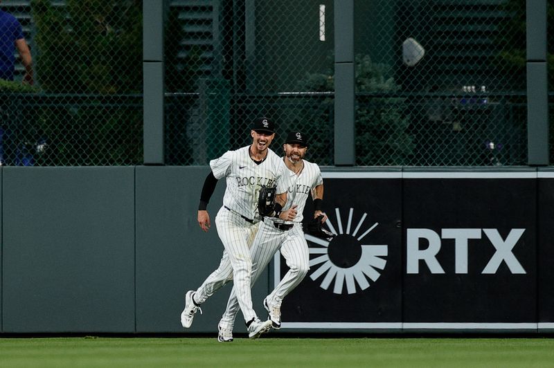 Jun 18, 2024; Denver, Colorado, USA; Colorado Rockies center fielder Brenton Doyle (9) reacts with right fielder Jake Cave (11) after making a play in the seventh inning against the Los Angeles Dodgers at Coors Field. Mandatory Credit: Isaiah J. Downing-USA TODAY Sports