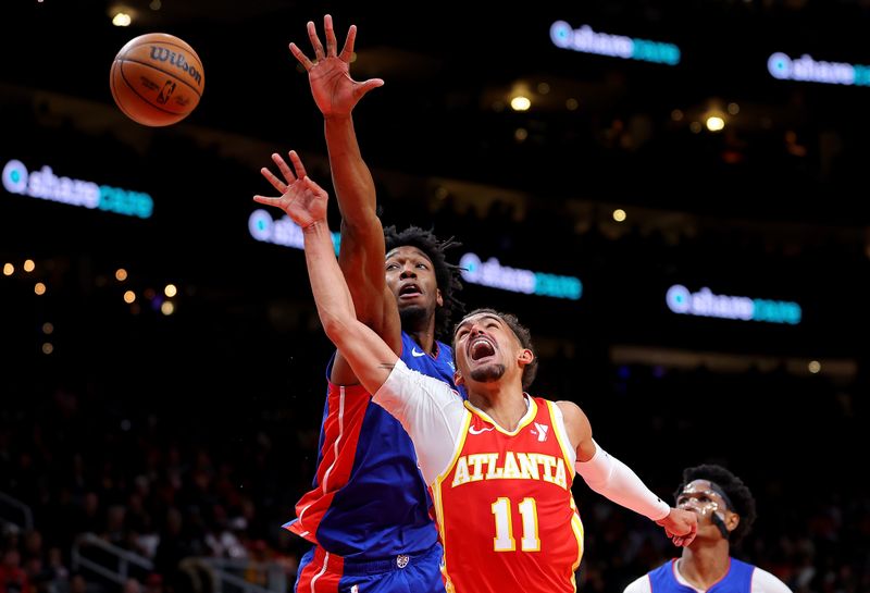 ATLANTA, GEORGIA - DECEMBER 18:  Trae Young #11 of the Atlanta Hawks attempts a shot against James Wiseman #13 of the Detroit Pistons during the second quarter at State Farm Arena on December 18, 2023 in Atlanta, Georgia.  NOTE TO USER: User expressly acknowledges and agrees that, by downloading and/or using this photograph, user is consenting to the terms and conditions of the Getty Images License Agreement.  (Photo by Kevin C. Cox/Getty Images)