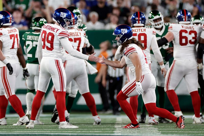 New York Giants place kicker Jude McAtamney (99) reacts with punter Jamie Gillan (6) after kicking a field goal during a preseason NFL football game against the New York Jets Saturday, Aug. 24, 2024, in East Rutherford, N.J. (AP Photo/Adam Hunger)