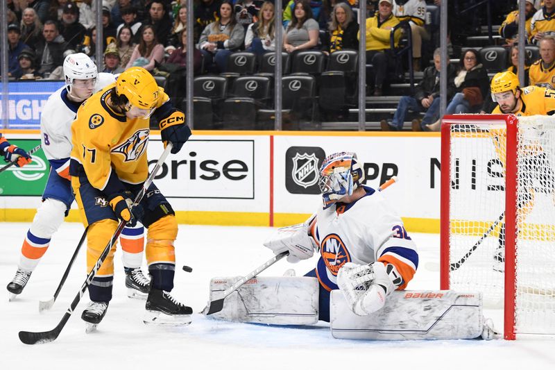 Jan 13, 2024; Nashville, Tennessee, USA; Nashville Predators right wing Luke Evangelista (77) deflects a shot wide of New York Islanders goaltender Ilya Sorokin (30) during the first period at Bridgestone Arena. Mandatory Credit: Christopher Hanewinckel-USA TODAY Sports