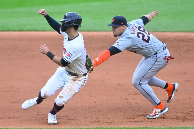 May 6, 2024; Cleveland, Ohio, USA; Detroit Tigers shortstop Javier Baez (28) tags out Cleveland Guardians center fielder Tyler Freeman (2) in the fifth inning at Progressive Field. Mandatory Credit: David Richard-USA TODAY Sports