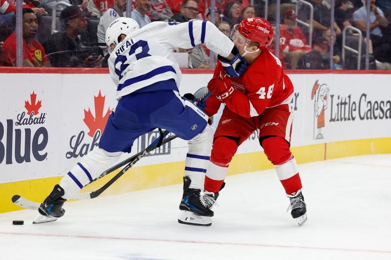 Oct 3, 2024; Detroit, Michigan, USA;  Toronto Maple Leafs defenseman Marshall Rifai (83) and Detroit Red Wings right wing Jonatan Berggren (48) battle for the puck in the second period at Little Caesars Arena. Mandatory Credit: Rick Osentoski-Imagn Images