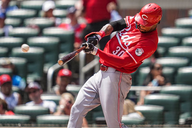 Jul 24, 2024; Cumberland, Georgia, USA; Cincinnati Reds center fielder Will Benson (30) hits a double against the Atlanta Braves during the eighth inning at Truist Park. Mandatory Credit: Dale Zanine-USA TODAY Sports