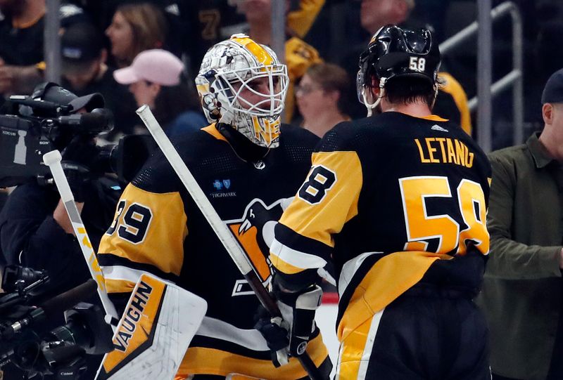 Apr 15, 2024; Pittsburgh, Pennsylvania, USA;  Pittsburgh Penguins goaltender Alex Nedeljkovic (39) and defenseman Kris Letang (58) celebrate after defeating the Nashville Predators at PPG Paints Arena. The Penguins won 4-2. Mandatory Credit: Charles LeClaire-USA TODAY Sports