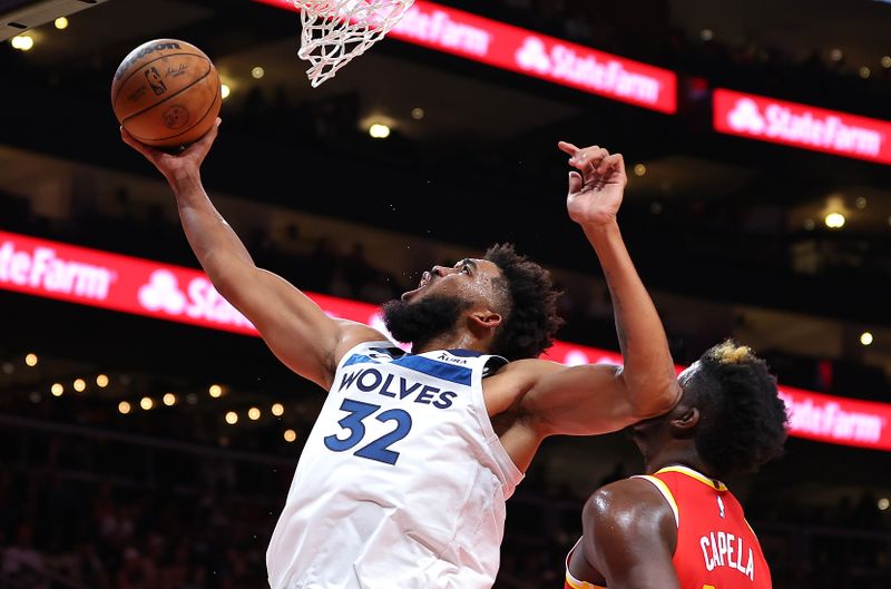 ATLANTA, GEORGIA - OCTOBER 30:  Karl-Anthony Towns #32 of the Minnesota Timberwolves draws a foul as he attacks the basket against Clint Capela #15 of the Atlanta Hawks during the second quarter at State Farm Arena on October 30, 2023 in Atlanta, Georgia.  NOTE TO USER: User expressly acknowledges and agrees that, by downloading and/or using this photograph, user is consenting to the terms and conditions of the Getty Images License Agreement.  (Photo by Kevin C. Cox/Getty Images)