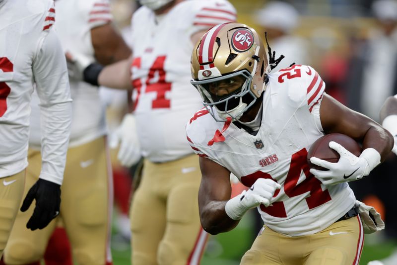 San Francisco 49ers running back Jordan Mason (24) warms up before an NFL football game against the Green Bay Packers on Sunday, Nov. 24, 2024 in Green Bay, Wis. (AP Photo/Matt Ludtke)