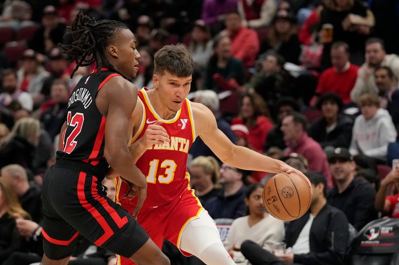 CHICAGO, ILLINOIS - APRIL 01: Bogdan Bogdanovic #13 of the Atlanta Hawks dribbles the ball against Ayo Dosunmu #12 of the Chicago Bulls during the first half at the United Center on April 01, 2024 in Chicago, Illinois. NOTE TO USER: User expressly acknowledges and agrees that, by downloading and or using this photograph, User is consenting to the terms and conditions of the Getty Images License Agreement. (Photo by Patrick McDermott/Getty Images)