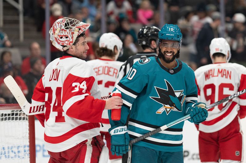 Jan 2, 2024; San Jose, California, USA; Detroit Red Wings goaltender Alex Lyon (34) and San Jose Sharks left wing Anthony Duclair (10) smile during the second period at SAP Center at San Jose. Mandatory Credit: Stan Szeto-USA TODAY Sports